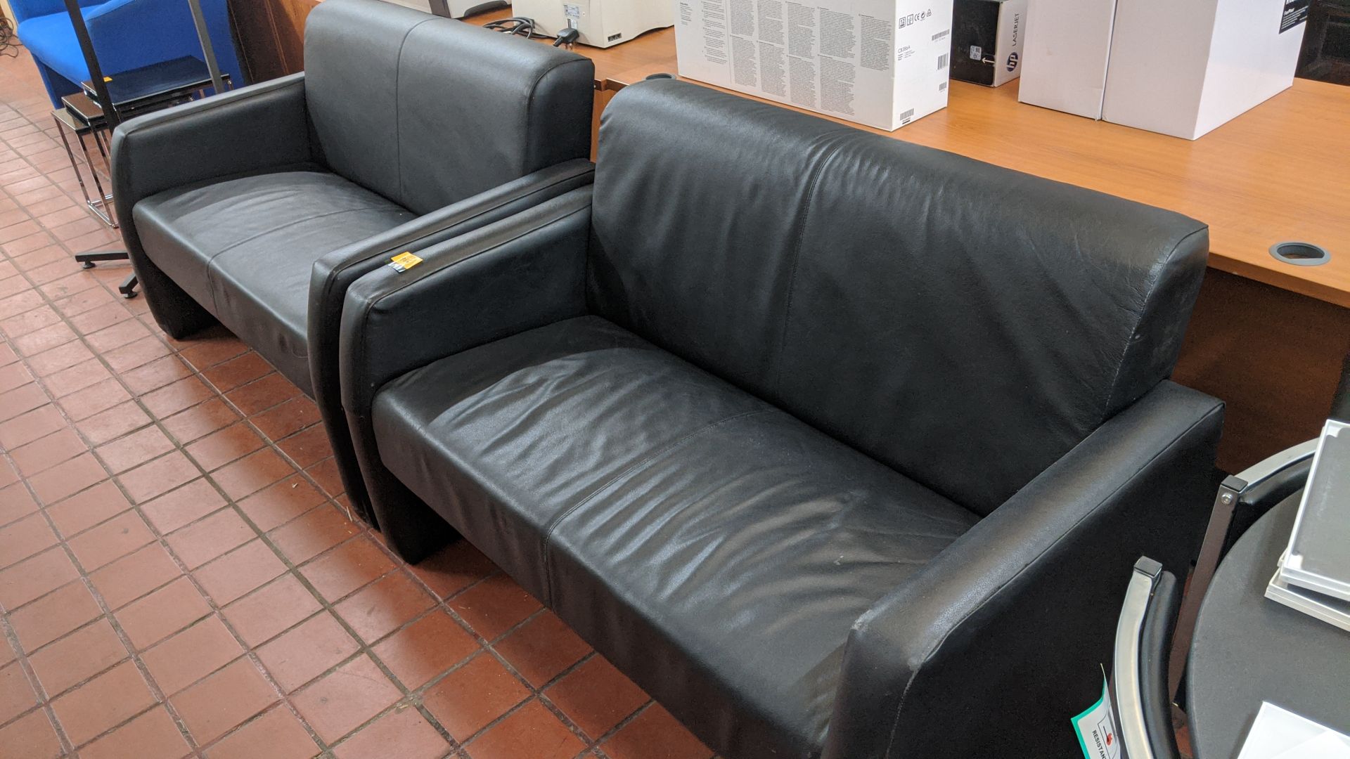 Pair of black leather-look sofas. This is one of a large number of lots in this sale being sold