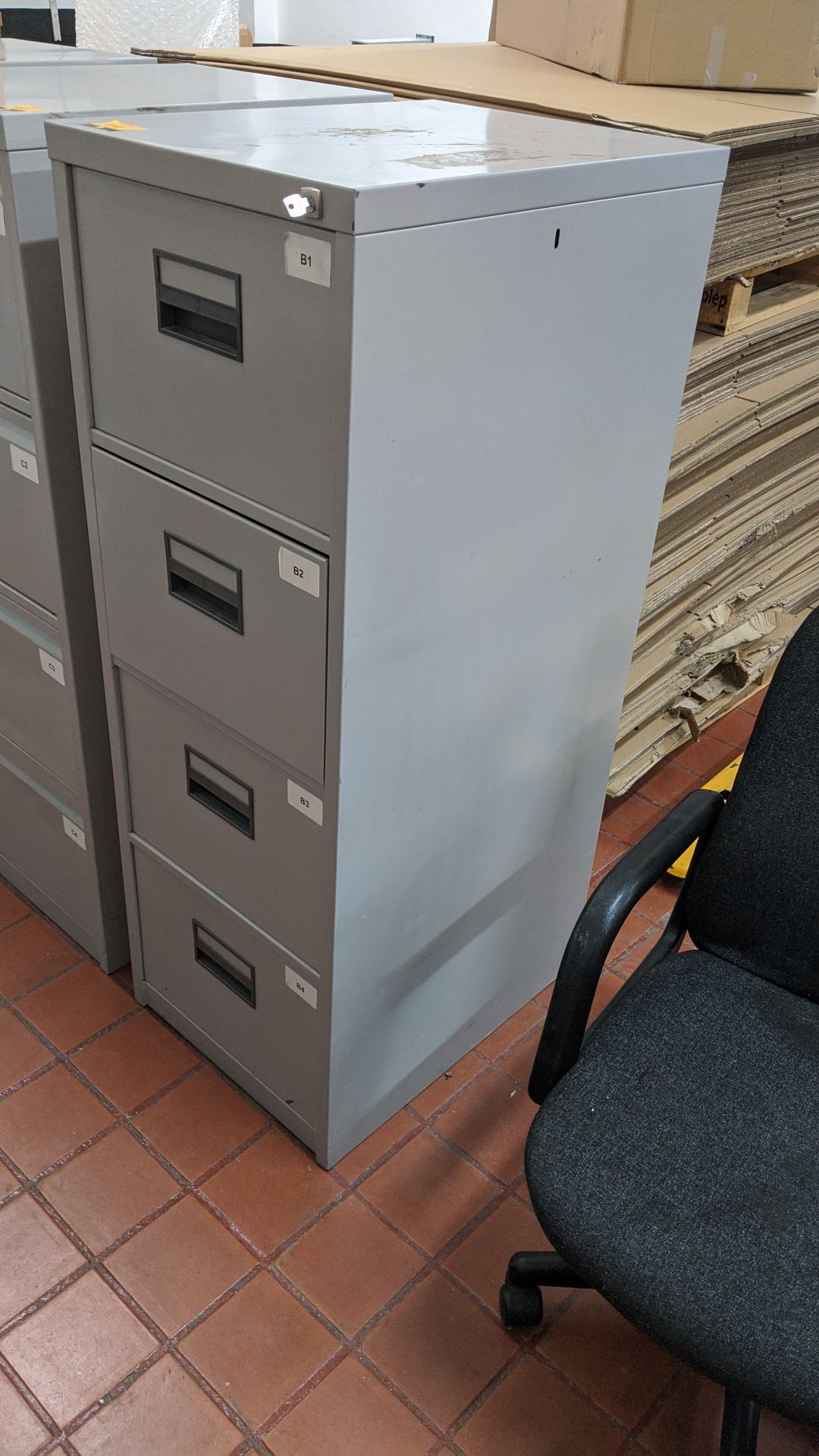 Pale grey metal 4-drawer filing cabinet with key. This is one of a large number of lots in this sale