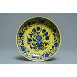 A Chinese yellow-ground blue and white 'lotus bouquet' plate, Qianlong mark, 19/20th C.