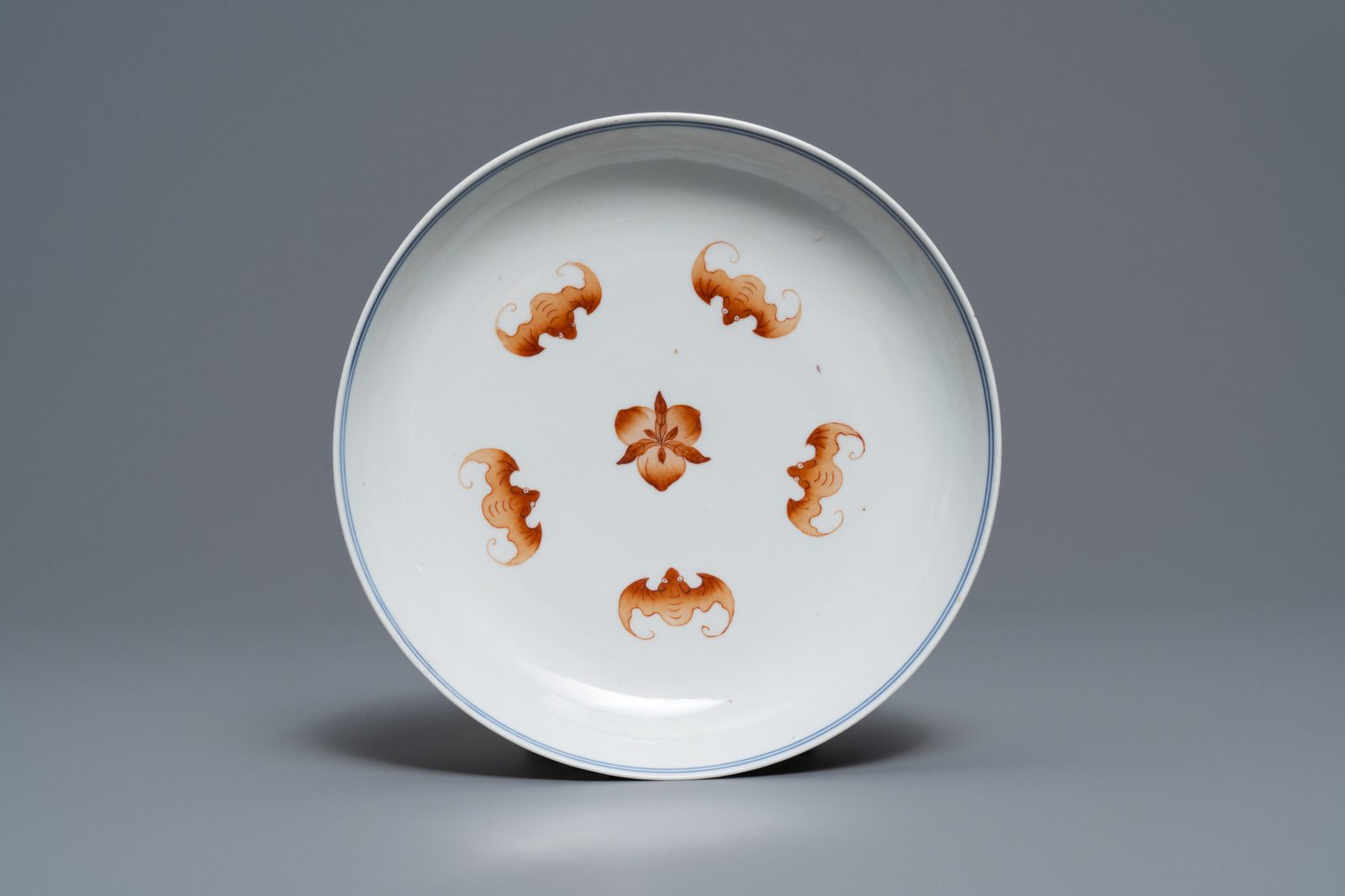 A Chinese iron red and blue and white 'bats and peaches' plate, 19th C.