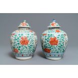 A pair of Chinese wucai vases and covers with boys among peonies, Transitional period