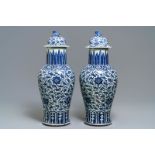 A pair of Chinese blue and white vases and covers with floral sprigs, 19th C.