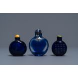 Three Chinese transparent blue glass snuff bottles, one inscribed, 18/19th C.