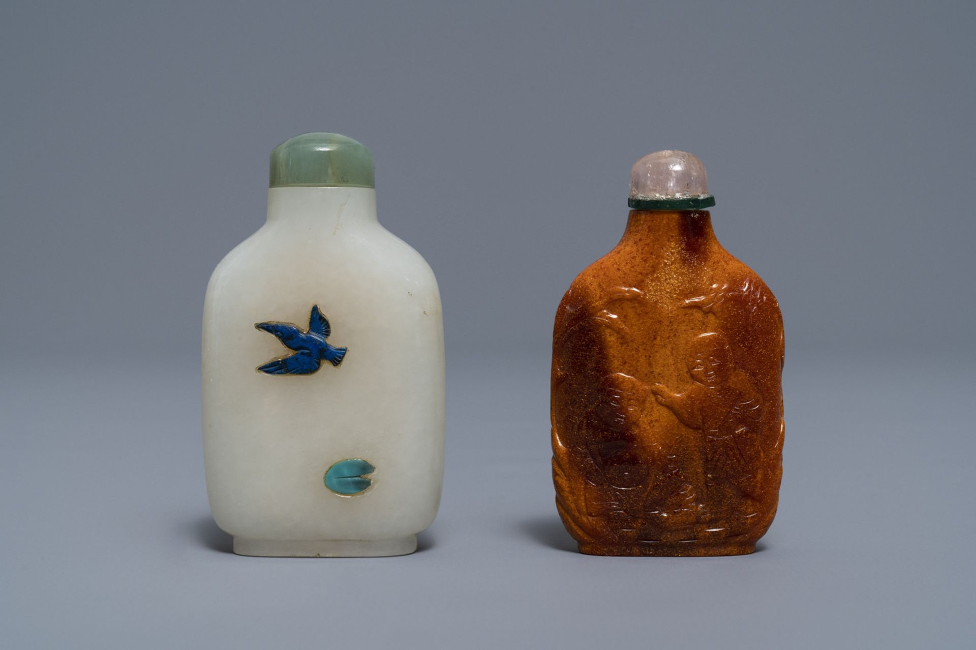 Two Chinese hardstone-embellished white jade and carved amber snuff bottles,18/19th C.