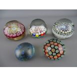 Four millefiori cane glass paperweights by Murano, Italy etc and an Isle of Wight iridescent glass