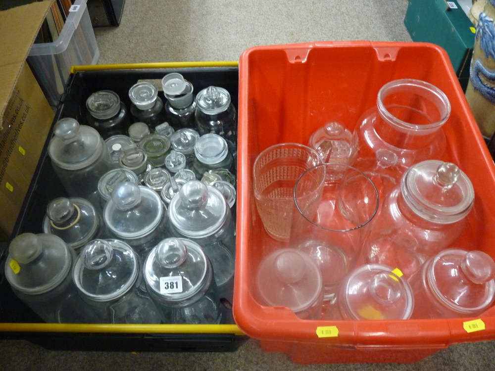 Two plastic crates of lidded and other glass storage jars