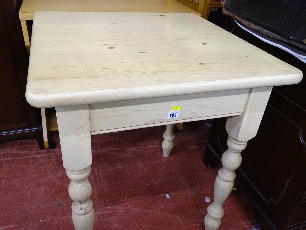 Modern light wood square topped kitchen table on turned supports