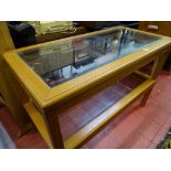 Two reproduction light wood glass topped coffee tables