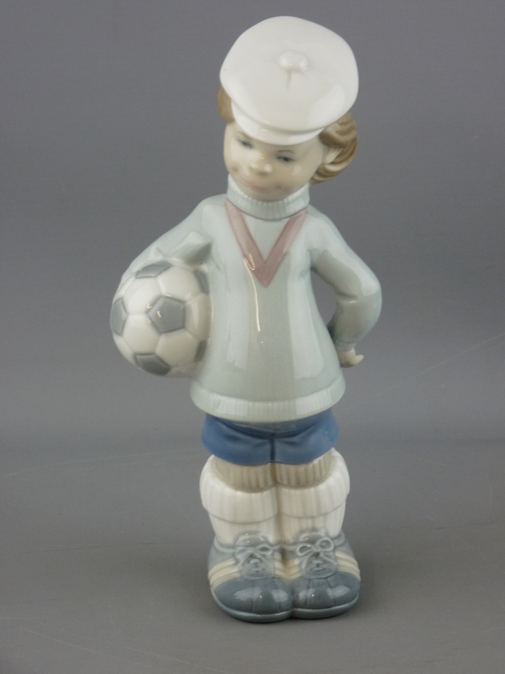 Lladro porcelain figurines of a young boy with football