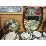 Convex brass framed circular wall mirror and an oval mahogany framed wall mirror