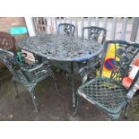 A green metal garden table with four chairs
