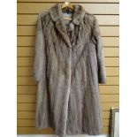 A full length mink fur coat with cover