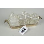 A gondola-shaped silver three-bottle condiment dish Condition reports are provided on request by