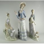 A Lladro figure of a lady with goose & puppy, a Lladro figure with a lady in parasol (damage) & a