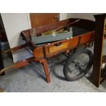 A wooden hand cart with metal chassis and pneumatic tyres on spoked wheels, bears plaque for