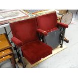 A pair of vintage numbered folding red upholstered cinema seats removed from a South Wales cinema