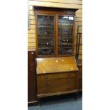 A vintage bureau bookcase composed of sloped front & three graduated doors below a two-door astragal