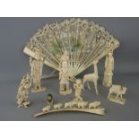Collection of circa 1900 carved ivory, bone and moulded figures with a boxed painted silk fan