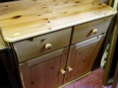 Neat reproduction pine dresser base of two drawers and cupboard doors on bun feet
