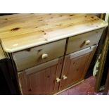 Neat reproduction pine dresser base of two drawers and cupboard doors on bun feet