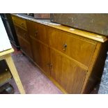 Oak mid Century sideboard having a mixed arrangement of drawers and cupboards with central drop down