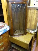Wall hanging reproduction mahogany glass front corner cupboard and a twin flap oak two tier trolley