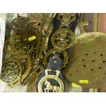 Wicker basket with horse brasses contents, leather strap of horse brasses and other brassware