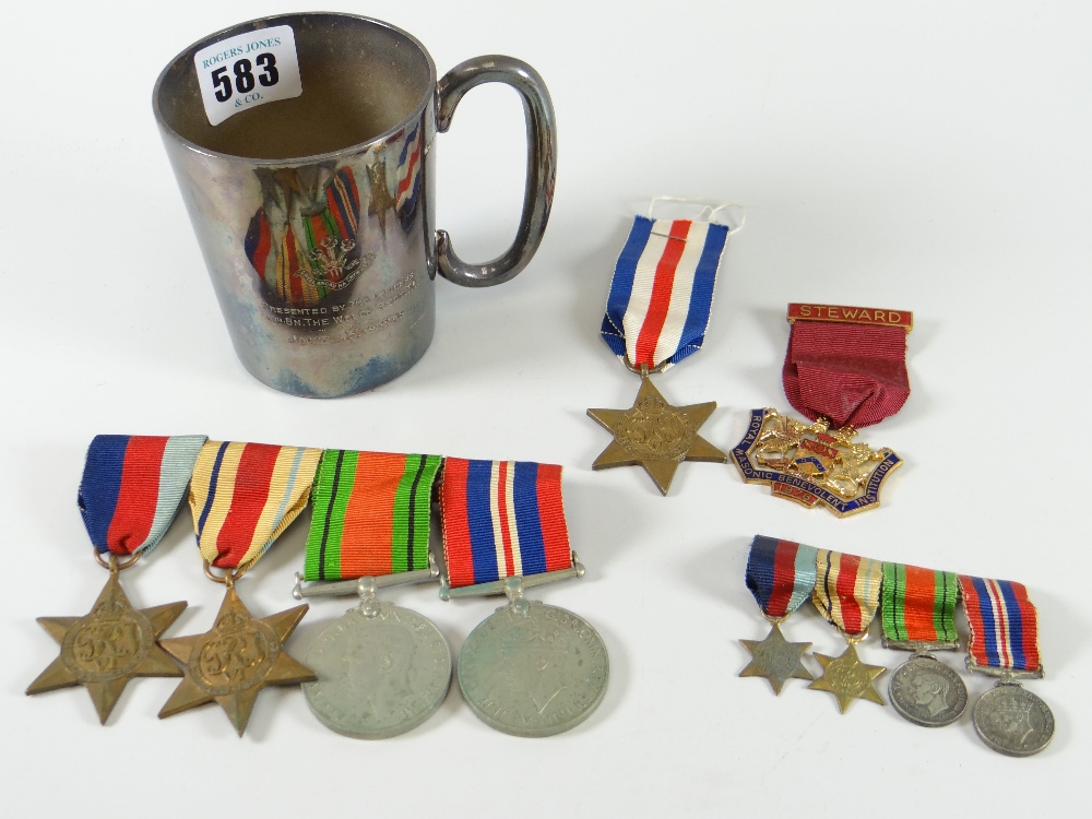 A regimental half-pint EPNS mug containing a bar of four WWII medals (unnamed), similar miniatures &