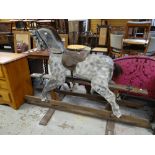 A vintage mottled grey rocking horse on wooden stand Condition reports provided on request by