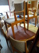 An oval / circular Danish mid-century dining table and six chairs with padded seats and backs