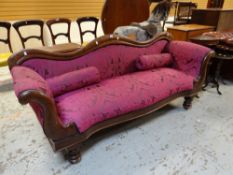 An antique serpentine back settee with roll sides and on turned supports, having pink purple