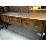 A nineteenth century oak three-drawer dresser base on turned and block supports, 181cms wide