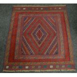 A rust and blue patterned Gazak rug, 132 x 121cms Condition reports provided on request by email for