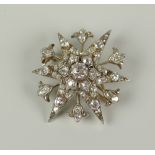DIAMOND ENCRUSTED STARBURST BROOCH / PENDANT, having central stone (0.3ct approx.) surrounded by