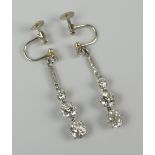 PAIR OF GRADUATED DIAMOND DROP EARRINGS having small diamond above diamond chip bar above three