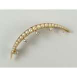 GRADUATED DIAMOND AND SEED PEARL SET CRESCENT BROOCH IN YELLOW METAL SETTING. 5.2 grams