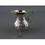 A VICTORIAN SILVER CREAM JUG with raised swan and floral decoration and front vacant cartouche,