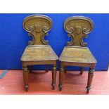 A PAIR OF VICTORIAN MAHOGANY SHIELDBACK HALL CHAIRS having scrolled decoration and tapering