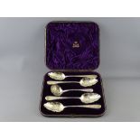 A FINE CASED SET OF FOUR GEORGIAN SILVER FRUIT SERVING SPOONS with matching sifter, all with gilt