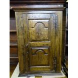 AN ANTIQUE JOINED OAK SINGLE DOOR WALL CUPBOARD, a twin shaped panelled door with iron 'H' hinges