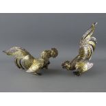 A PAIR OF STERLING SILVER & GILT DECORATED TABLE COCKERELS, 16 cms long approximately, marked '