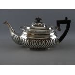 A VICTORIAN SILVER TEAPOT with gadrooned decoration, composite handle and lid finial, Birmingham