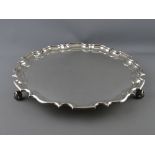 A FINE UNINSCRIBED CIRCULAR SILVER TRAY having a shaped and stepped border on three scrolled