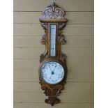 A VINTAGE ANEROID BAROMETER with ceramic dial and thermometer, set on a carved oak mount, 92 cms