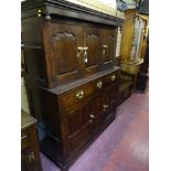 AN ANTIQUE OAK DEUDDARN having shaped and chamfered door panels with a central frieze of three