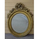 A GILT DECORATED OVAL WALL MIRROR, the bevelled edged plate surrounded by egg and dart moulding to