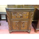 A CARVED ORIENTAL DRINKS CABINET, the carcass having profuse deep carved panelling showing various