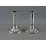 A PAIR OF SILVER CIRCULAR BASED COLUMN CANDLESTICKS with reeded bands, Birmingham 1912 (loaded)