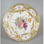 A NANTGARW PORCELAIN PLATE DECORATED WITH CENTRED FLORAL SPRAY the border gilded and moulded with