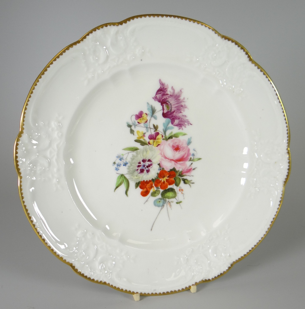 A NANTGARW PORCELAIN PLATE with lobed rim and having a moulded border with C-scrolls, flowers,